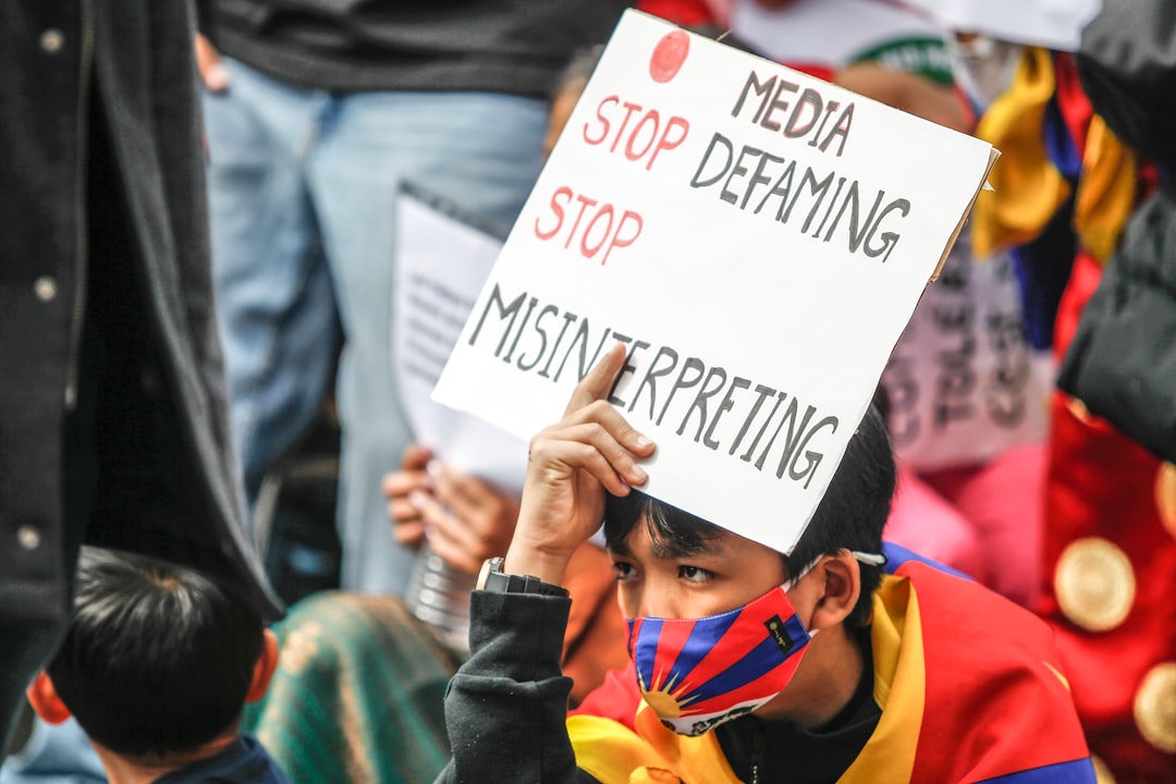 a young boy holding a sign that says stop defamiting