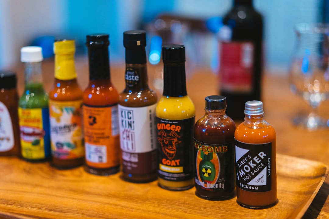 a wooden table topped with bottles of hot sauce