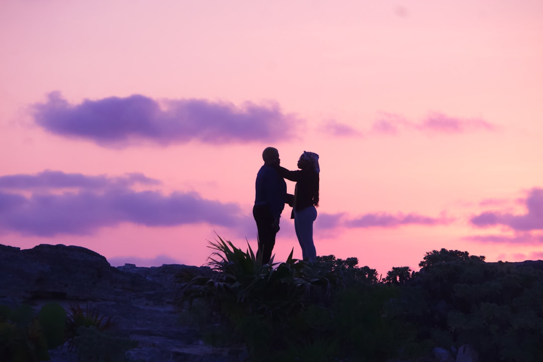 a couple of people standing on top of a hill