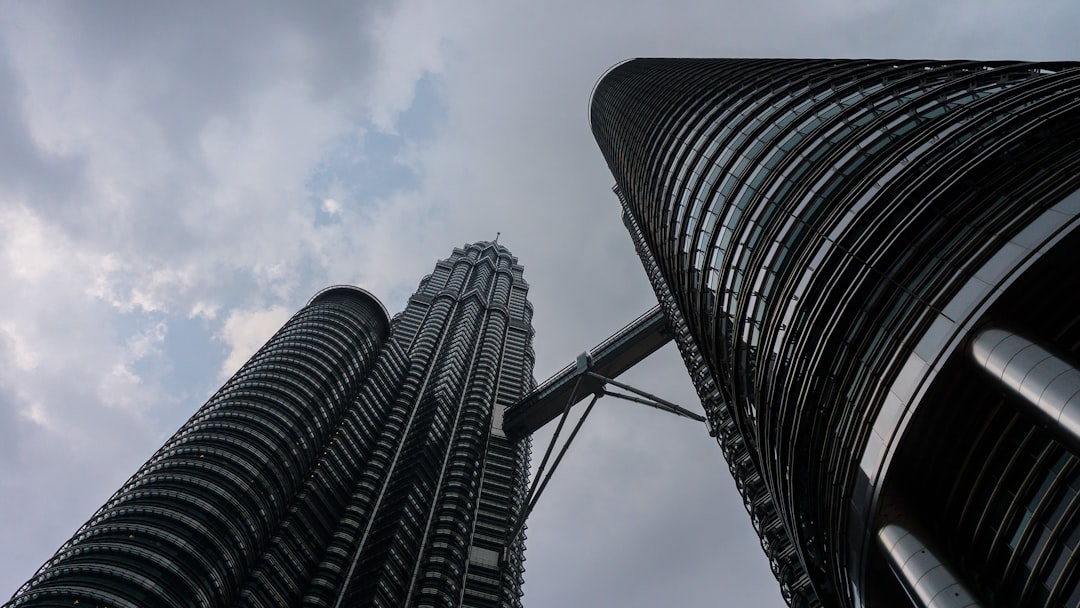 Looking up at two tall buildings in a city
